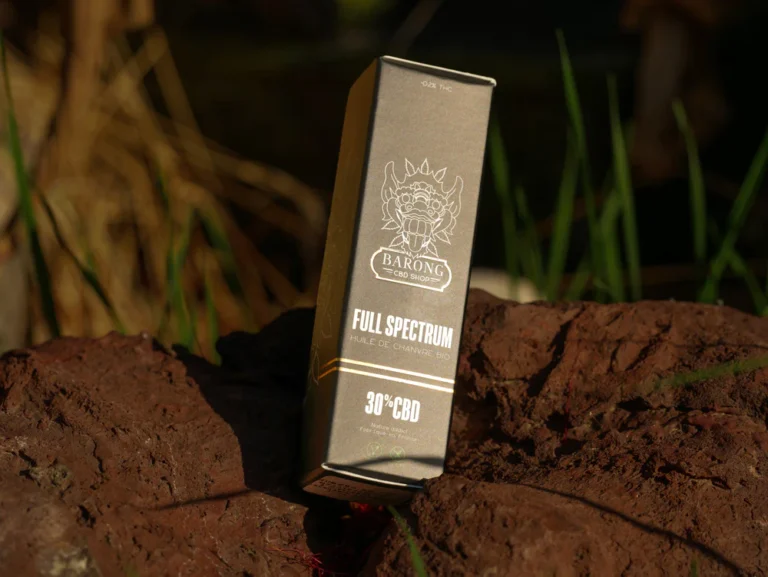 Photo du paquet de l'huile posé sur un rocher.